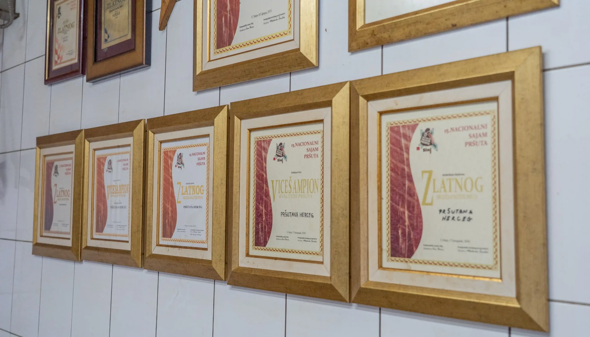 Zid s uokvirenim diplomama i priznanjima Pršutane Herceg